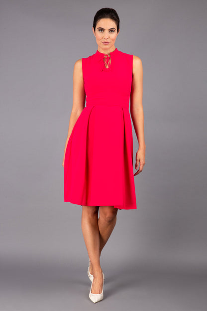 brunette model wearing diva catwalk oceana a-line swing skirt sleeveless dress with funnel neckline and tie detail in pink back