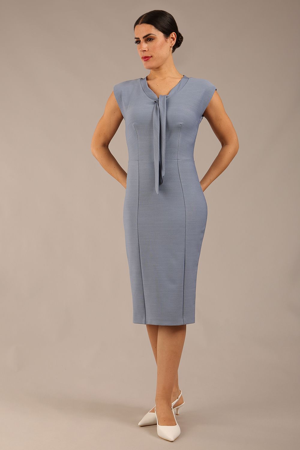 brunette model wearing a diva catwalk seed lucca tie detail cap sleeves pencil dress in steel blue colour front image