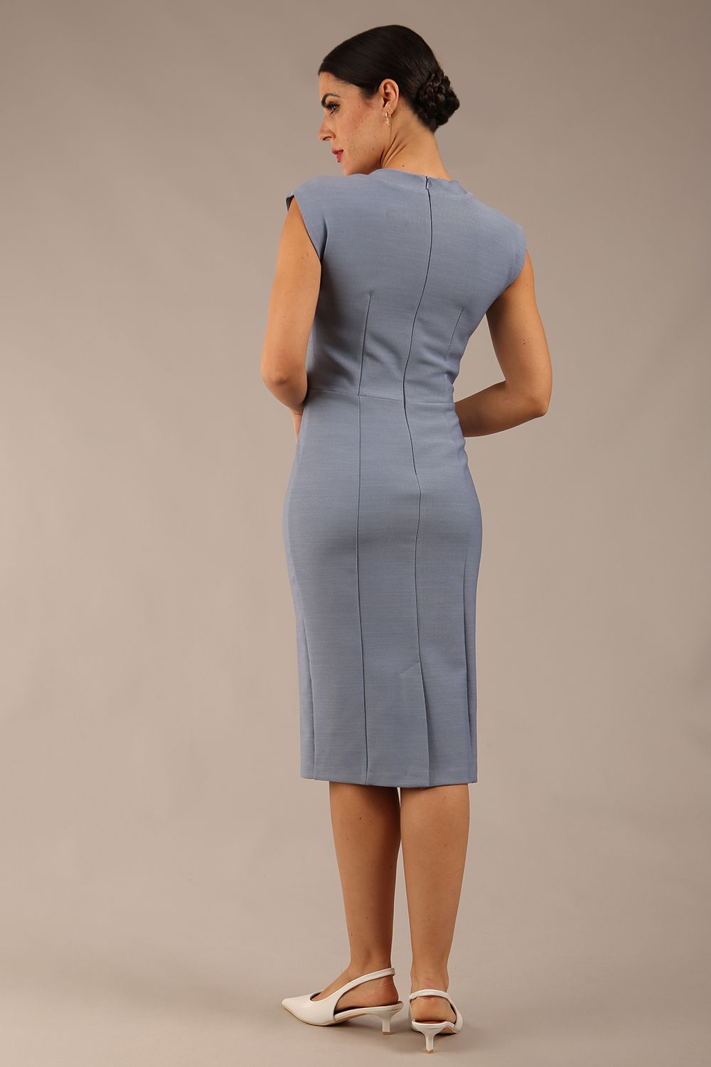 brunette model wearing a diva catwalk seed lucca tie detail cap sleeves pencil dress in steel blue colour back image