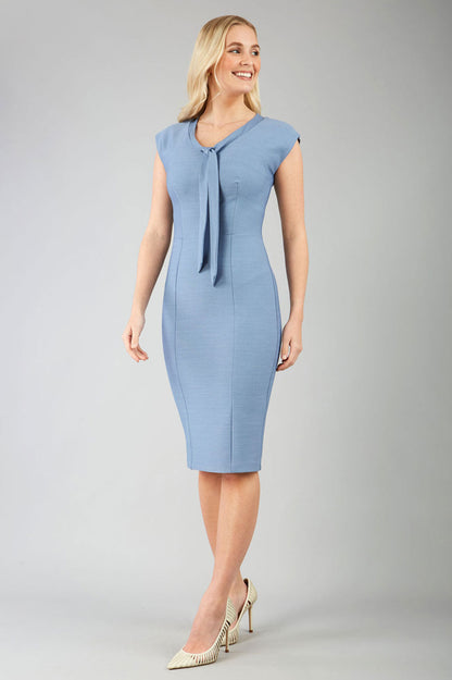 blond model wearing a diva catwalk seed lucca tie detail cap sleeves pencil dress in steel blue colour front image