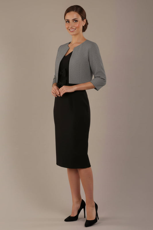 Woman wearing a black dress with a gray jacket on a beige background (Misty Grey)