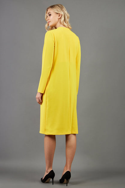 blonde model wearing the Diva Bliss Coat with round neckline in freesia yellow front image