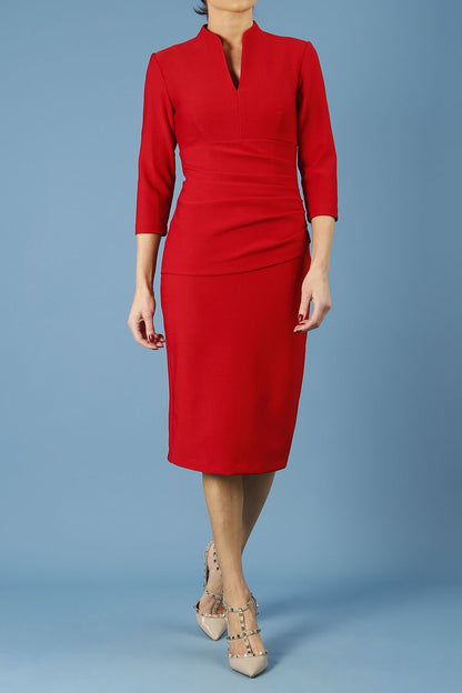 model is wearing diva catwalk seed holsworthy pencil dress with pleating on a tummy area and high neck with sleeves in cardinal red front