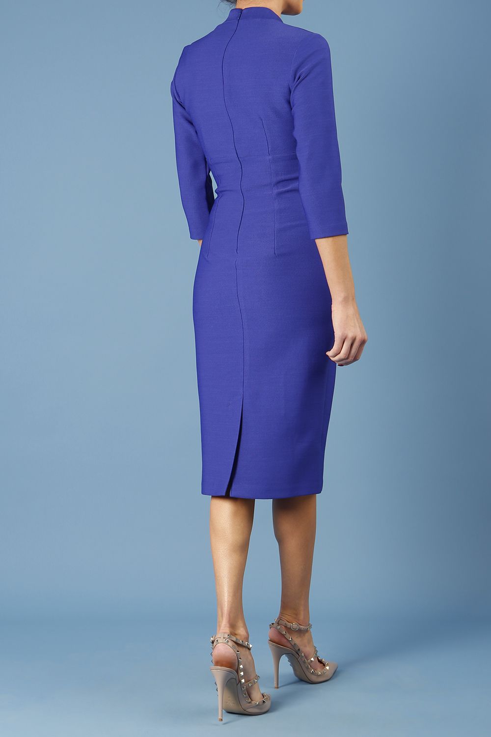 model is wearing diva catwalk seed holsworthy pencil dress with pleating on a tummy area and high neck with sleeves in palace blue front