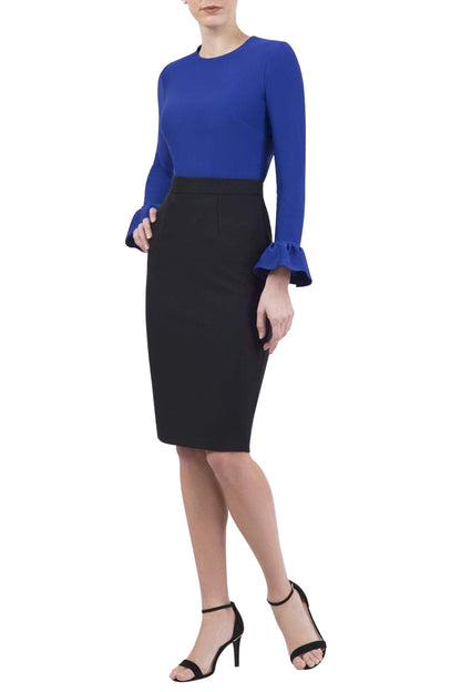 Woman in a blue top wearing the Diva Pacific top in cobalt blue colour front image standing on a rooftop with cityscape in the background