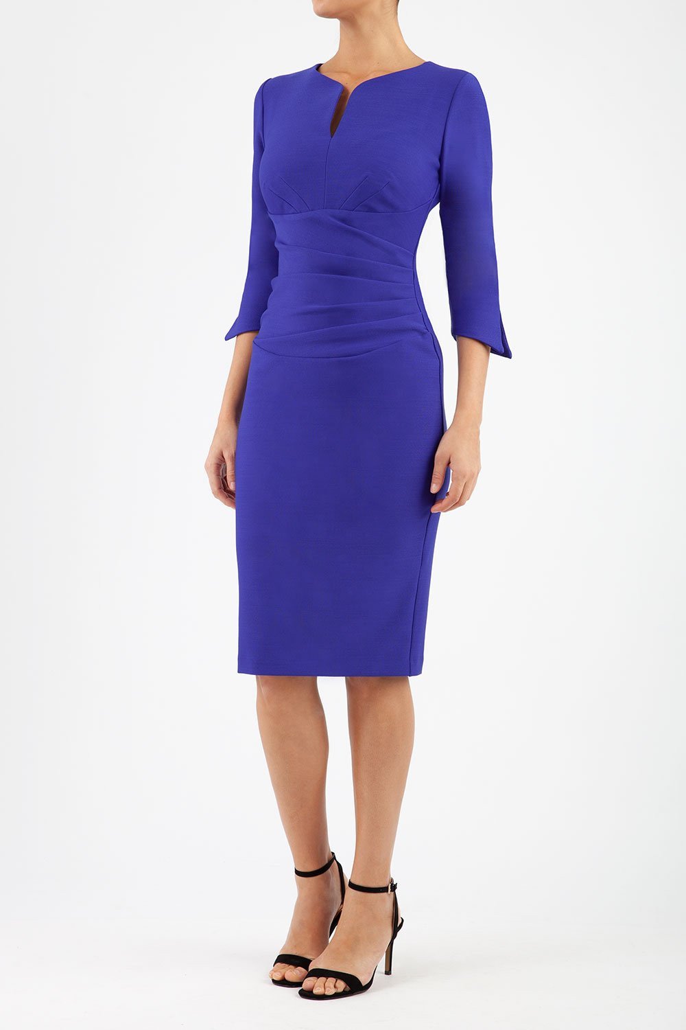 blonde model wearing seed tuscany pencil fitted dress in palace blue colour with a split in the neckline and split detail on sleeves front