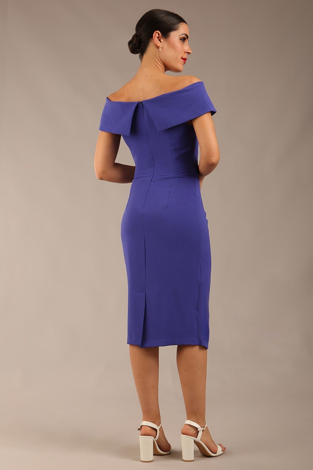 brunette model wearing diva catwalk pencil skirt dress sleeveless with lowered neckline and pleating on side in spectrum indigo colour front