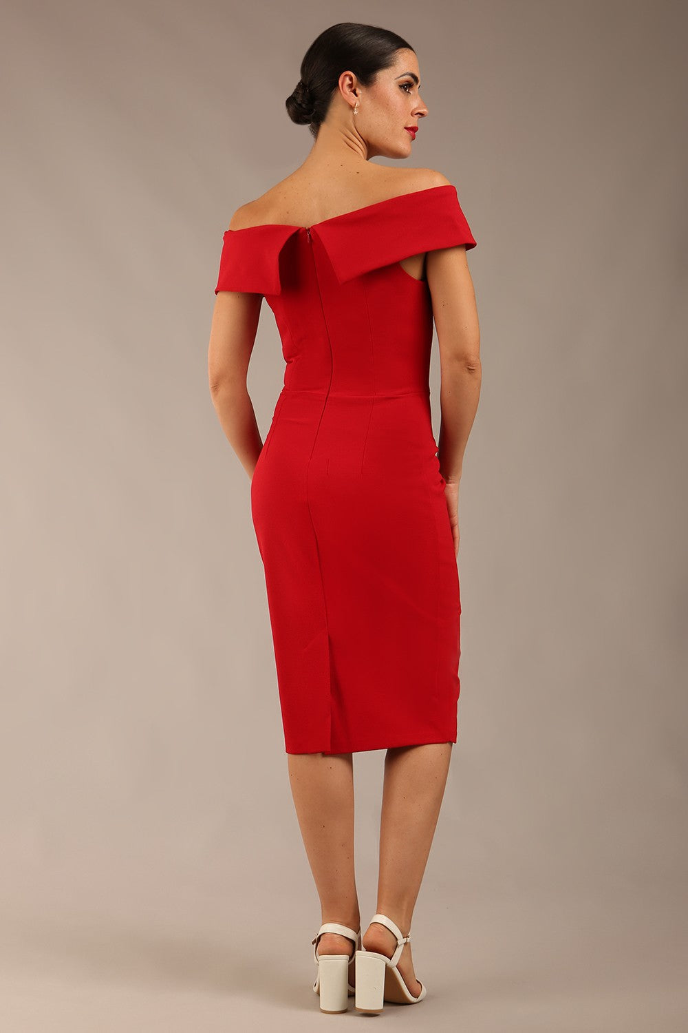 brunette model wearing diva catwalk pencil skirt dress sleeveless with lowered neckline and pleating on side in scarlet red colour front image