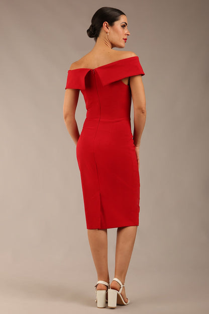 brunette model wearing diva catwalk pencil skirt dress sleeveless with lowered neckline and pleating on side in scarlet red colour front image