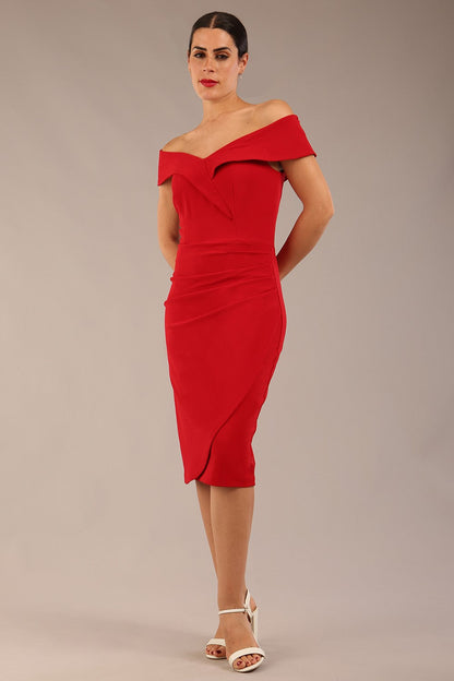 brunette model wearing diva catwalk pencil skirt dress sleeveless with lowered neckline and pleating on side in scarlet red colour front image