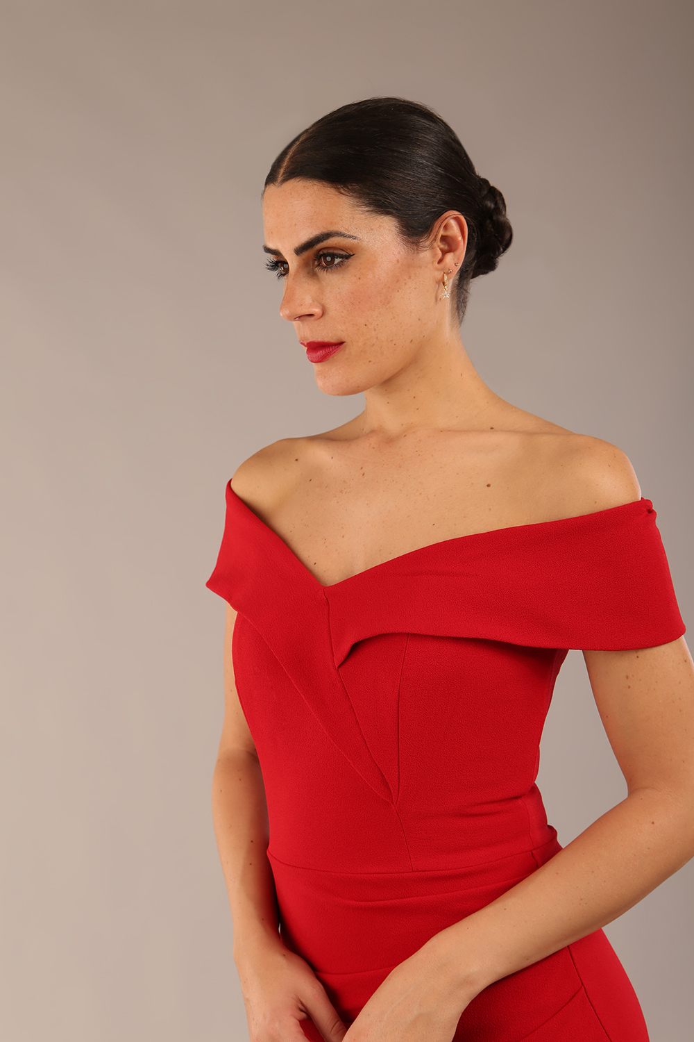 brunette model wearing diva catwalk pencil skirt dress sleeveless with lowered neckline and pleating on side in scarlet red colour front image