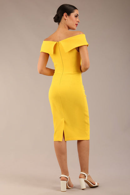 brunette model wearing diva catwalk pencil skirt dress sleeveless with lowered neckline and pleating on side in freesia yellow colour front image