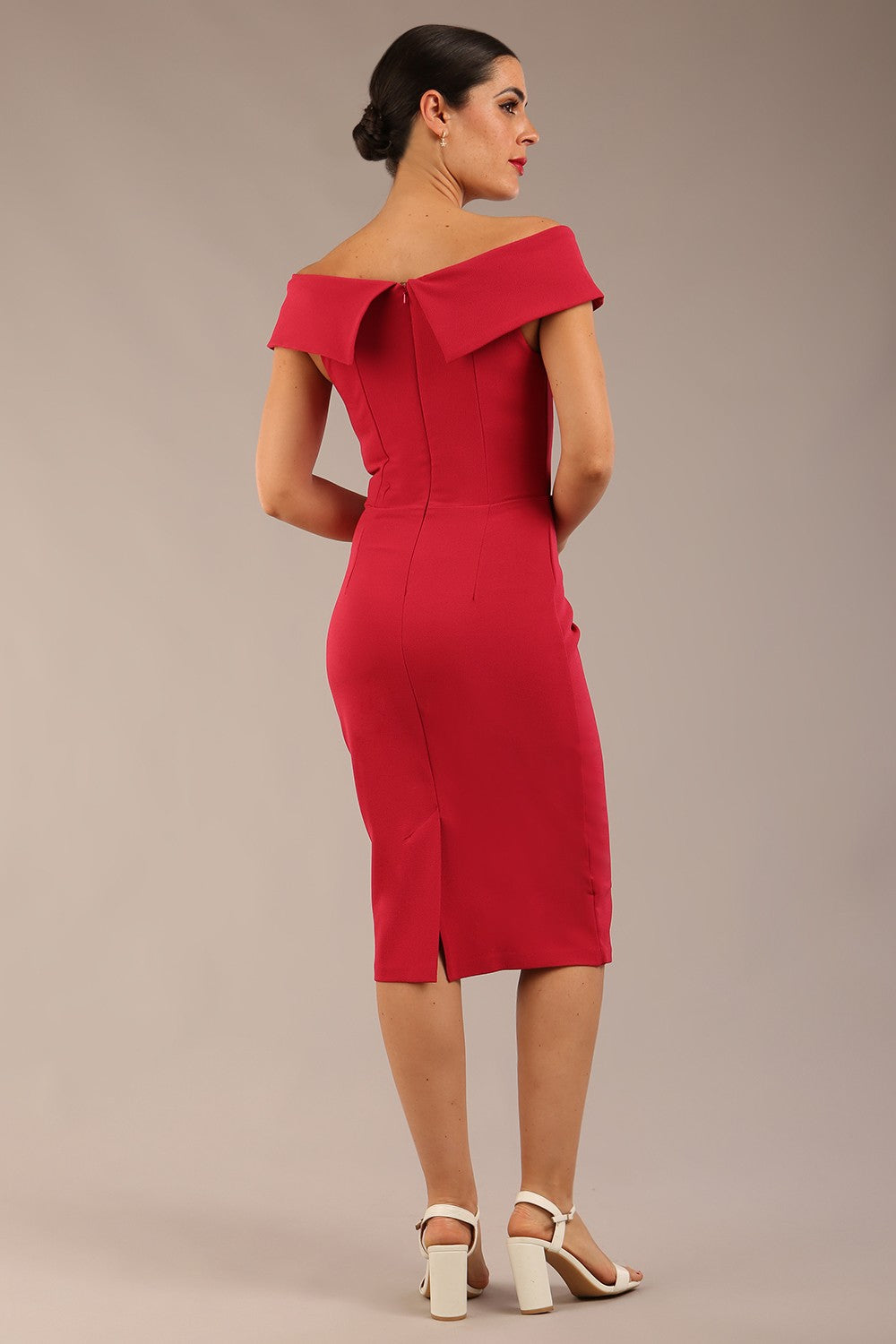 brunette model wearing diva catwalk pencil skirt dress sleeveless with lowered neckline and pleating on side in dazzle pink colour front image