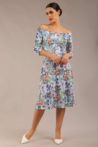 brunette model is wearing a diva catwalk islay a-line wing print dress off shoulder and knee length in water garden print front image