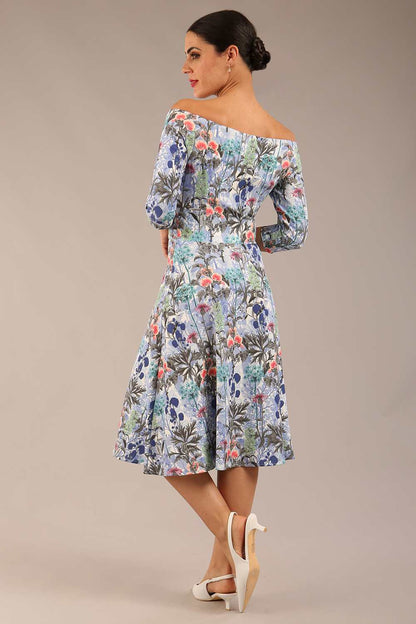 brunette model is wearing a diva catwalk islay a-line wing print dress off shoulder and knee length in water garden print front image