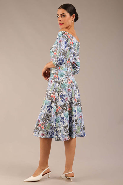 brunette model is wearing a diva catwalk islay a-line wing print dress off shoulder and knee length in water garden print front image