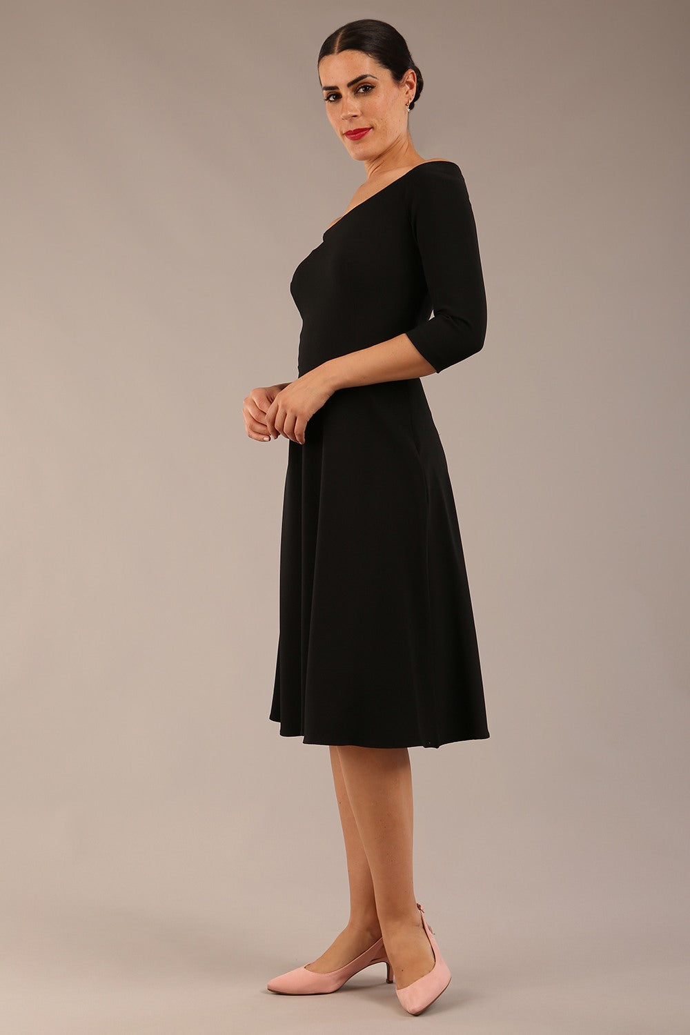 brunette model is wearing diva catwalk off shoulder swing a-line islay dress with sleeves in black colour front image 