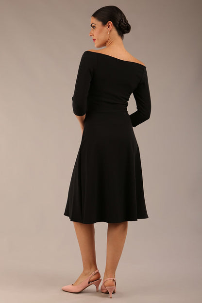 brunette model is wearing diva catwalk off shoulder swing a-line islay dress with sleeves in black colour front image 