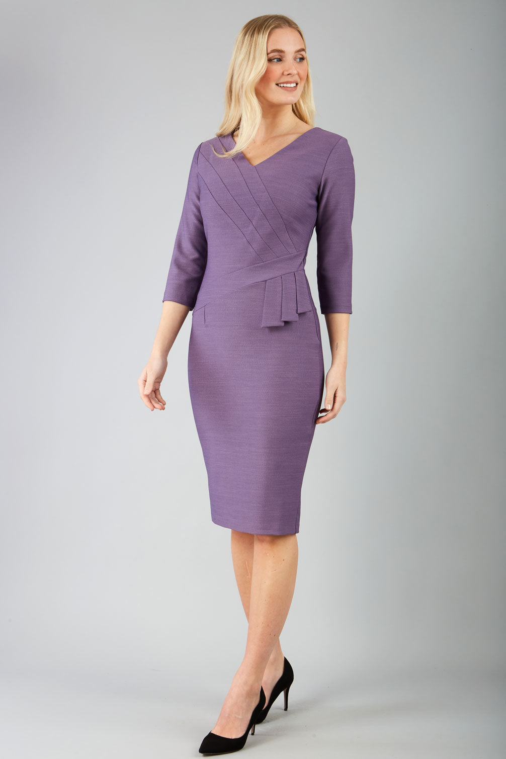 A model wearing a purple, sleeved pencil dress with a textured bodice and a V-neckline.