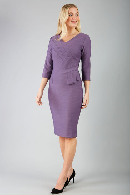 A model wearing a purple, sleeved pencil dress with a textured bodice and a V-neckline.