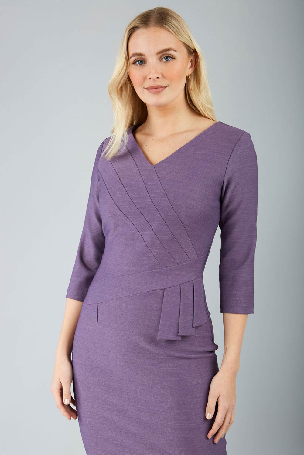 A model wearing a purple, sleeved pencil dress with a textured bodice and a V-neckline.