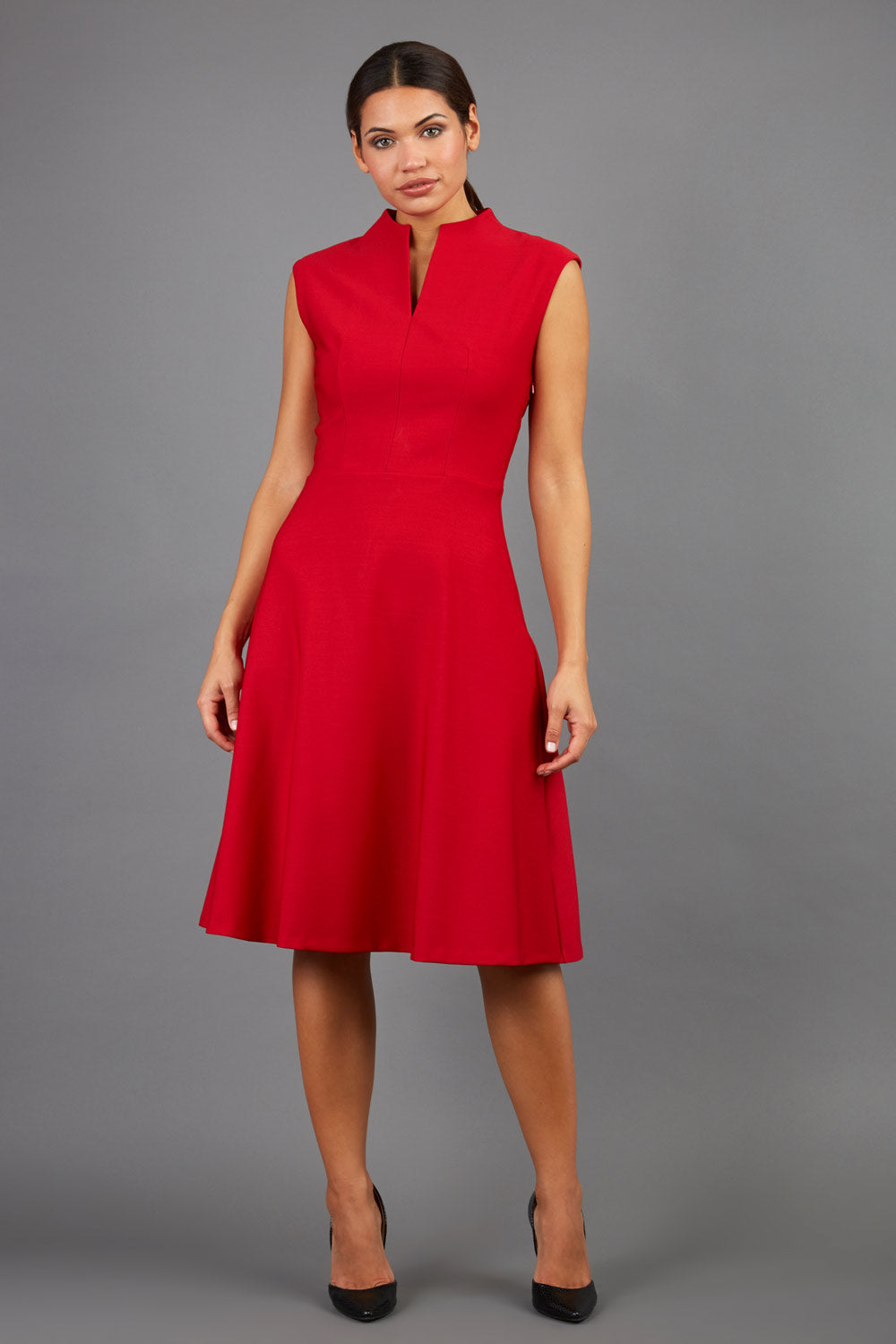 Brunette Model is wearing a sleeveless swing high neck dress with high neck in cardinal red by Diva Catwalk front