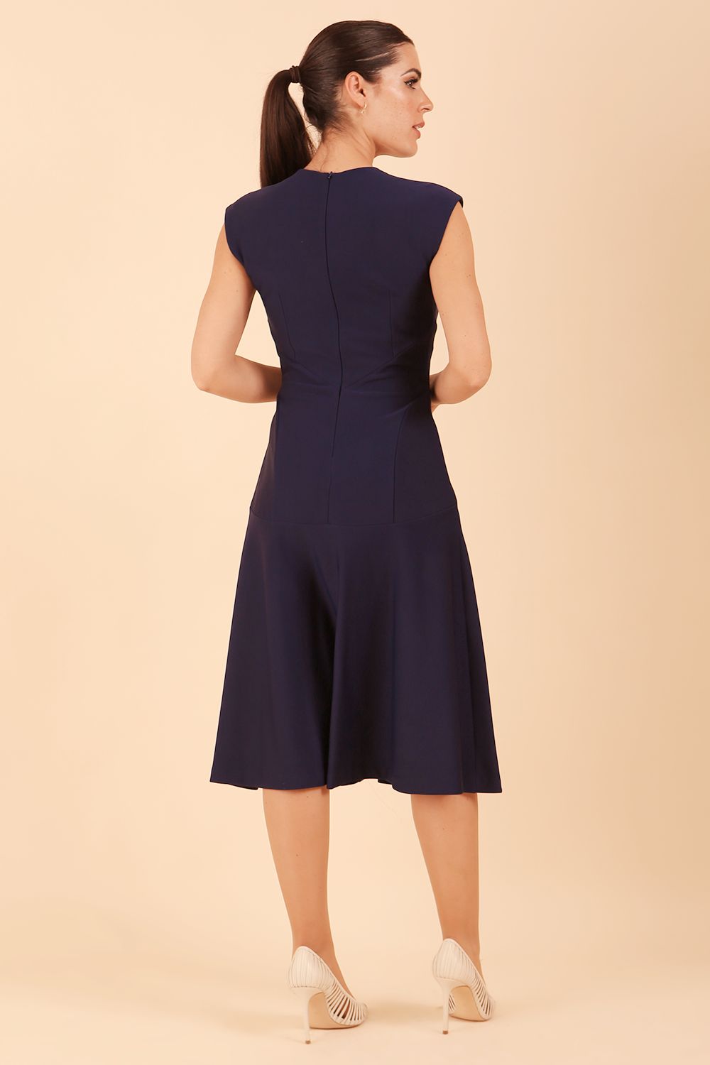 model wearing diva catwalk rochelle swing skirt a line dress without sleeves with a low v neck in navy front