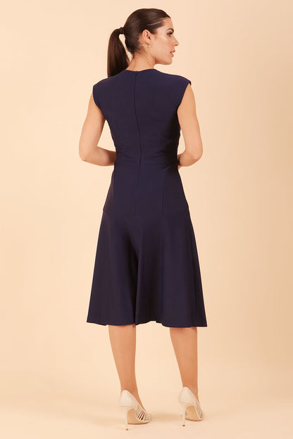 model wearing diva catwalk rochelle swing skirt a line dress without sleeves with a low v neck in navy front