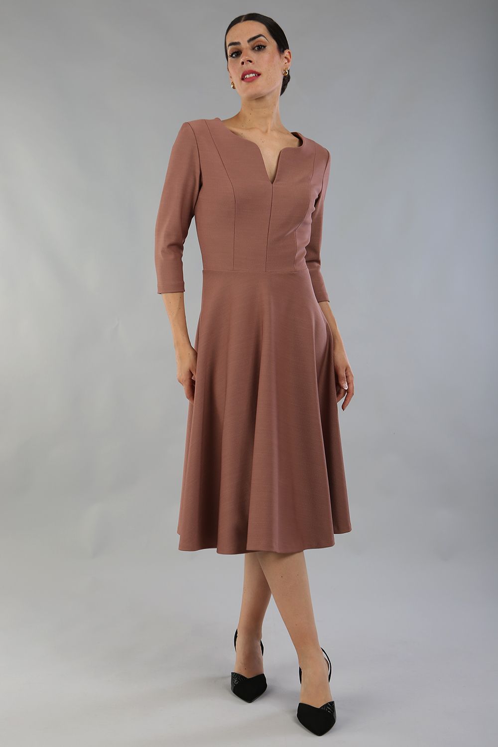 model wearing a diva catwalk Seed Corsham Swing Dress with 3/4 sleeve and below the knee length with v slit detail on the neckline in acorn brown colour