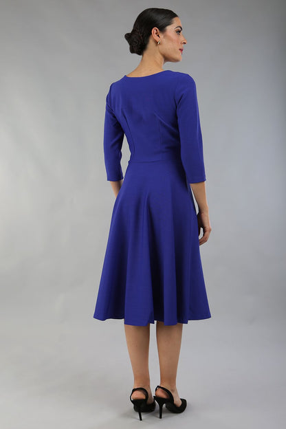 model wearing a diva catwalk Seed Corsham Swing Dress with 3/4 sleeve and below the knee length with v slit detail on the neckline in palace blue colour