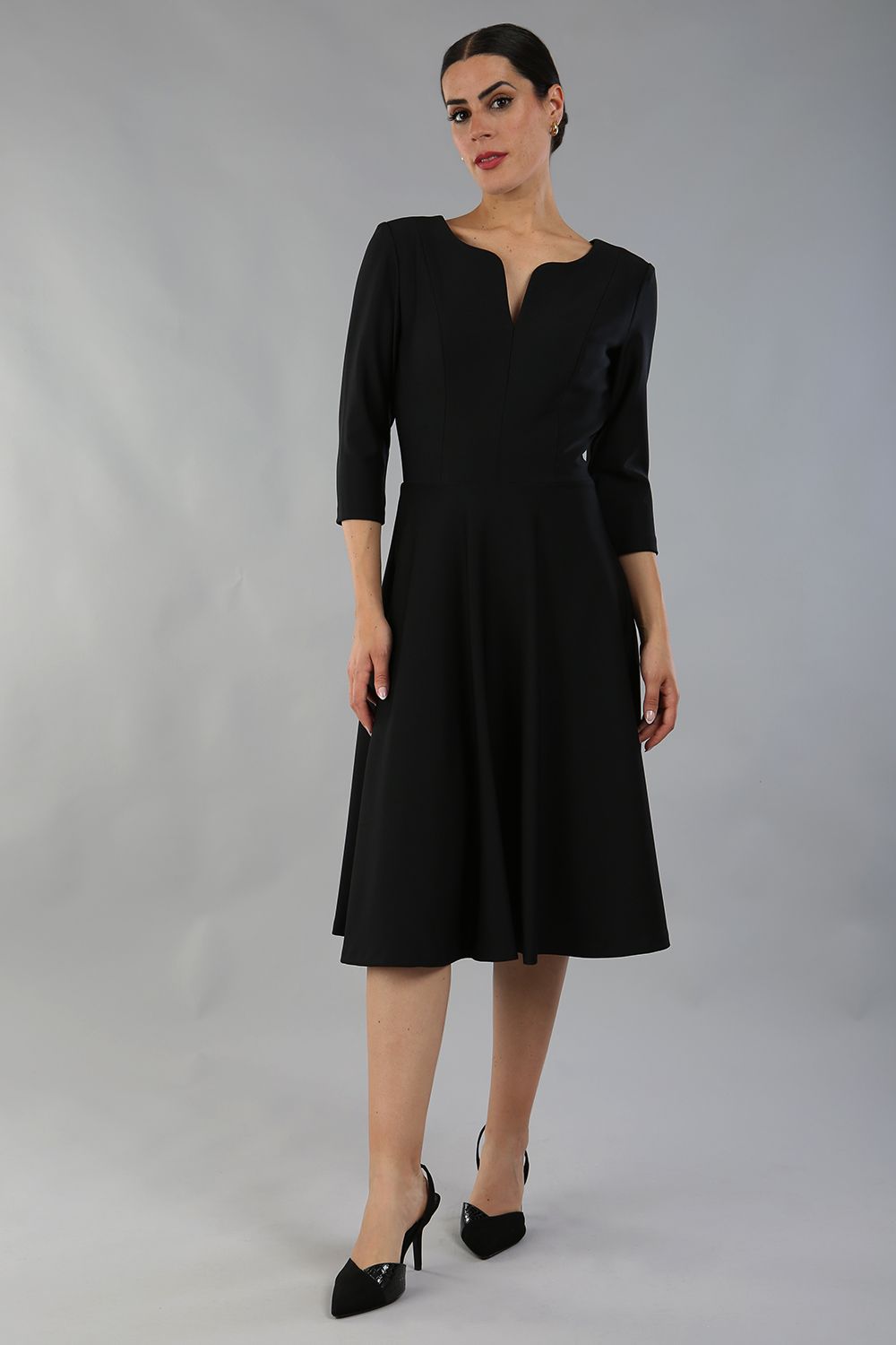model wearing a diva catwalk Seed Corsham Swing Dress with 3/4 sleeve and below the knee length with v slit detail on the neckline in black colour