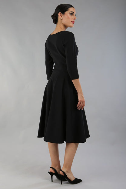 model wearing a diva catwalk Seed Corsham Swing Dress with 3/4 sleeve and below the knee length with v slit detail on the neckline in black colour