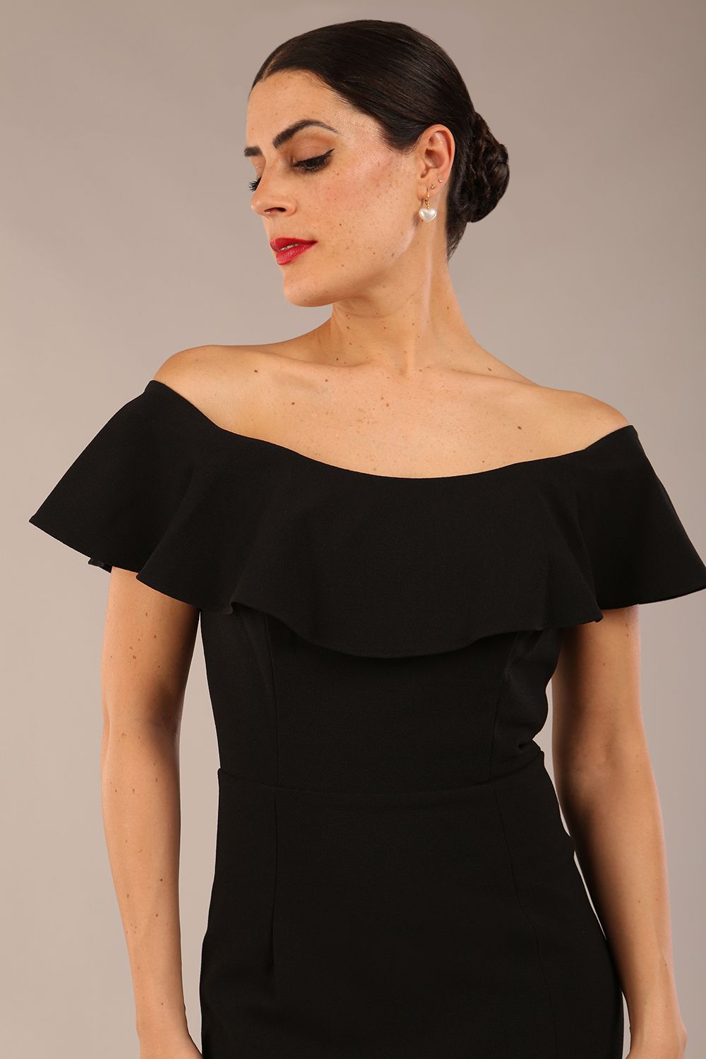 brunette model wearing diva catwalk pencil dress with off shoulder frilled front and bardot neckline in black colour front (Black)
