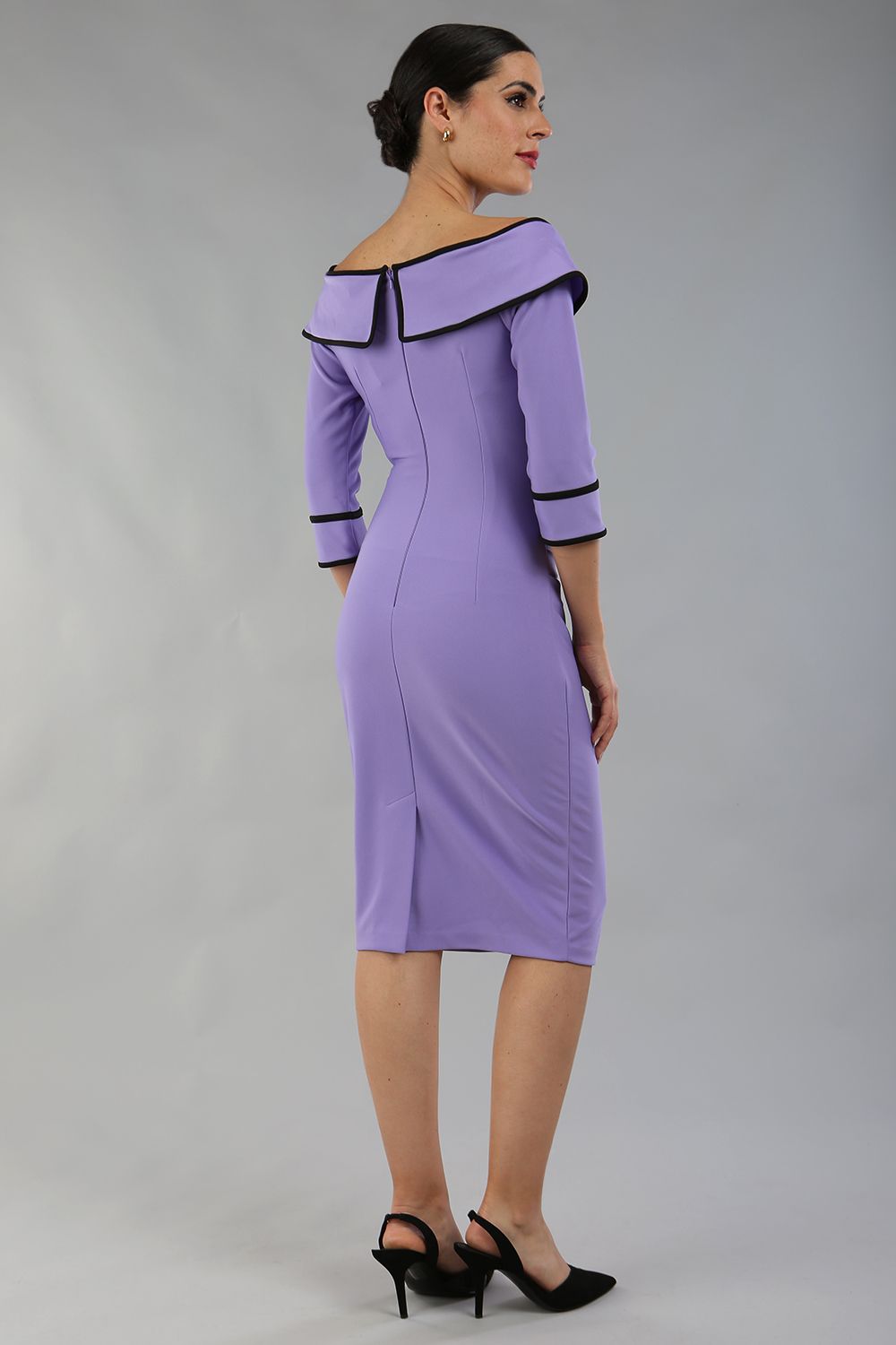 model wearing a diva catwalk Paige Bi-Stretch Dress with 3/4 sleeve, knee length, Fold over off-shoulder neckline with bow detail and with Contrast piping on sleeve cuffs and neckline in Lilac Wisteria and black colour