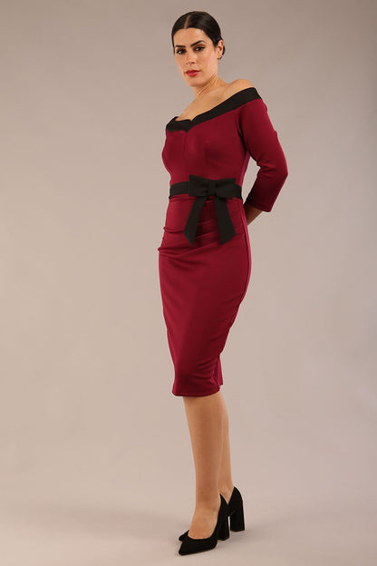 brunette model wearing diva catwalk luma pencil skirt dress with contrasting bow off shoulder with sleeves in blissful burgundy front