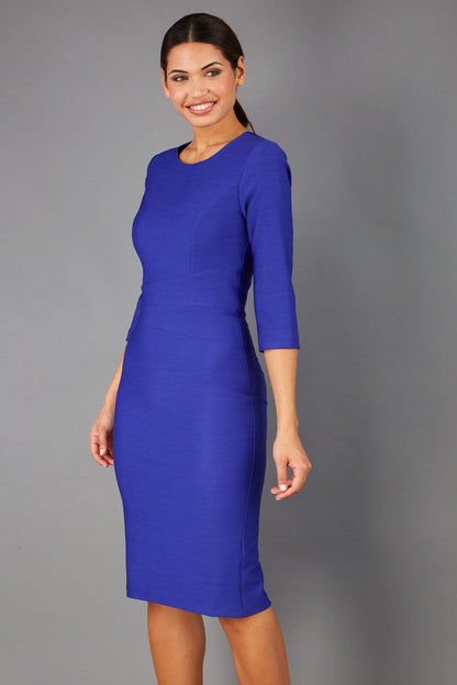brunette model is wearing diva catwalk seed rosa plain dress with rounded neckline in palace blue front