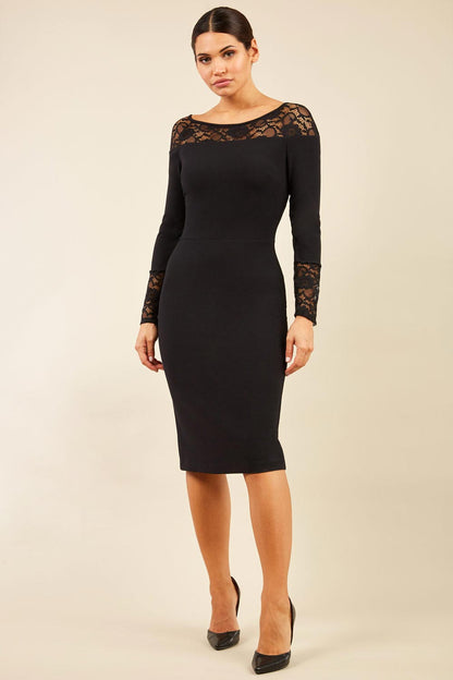 brunette model wearing diva catwalk black lace pencil dress with long sleeves and rounded lace neckline with the lace covering shoulders front