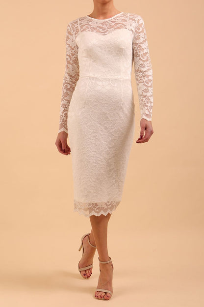 Model wearing a diva catwalk Montana Lace Dress with long lace sleeve and knee length with round lace neckline  in Ivory Cream colour front side