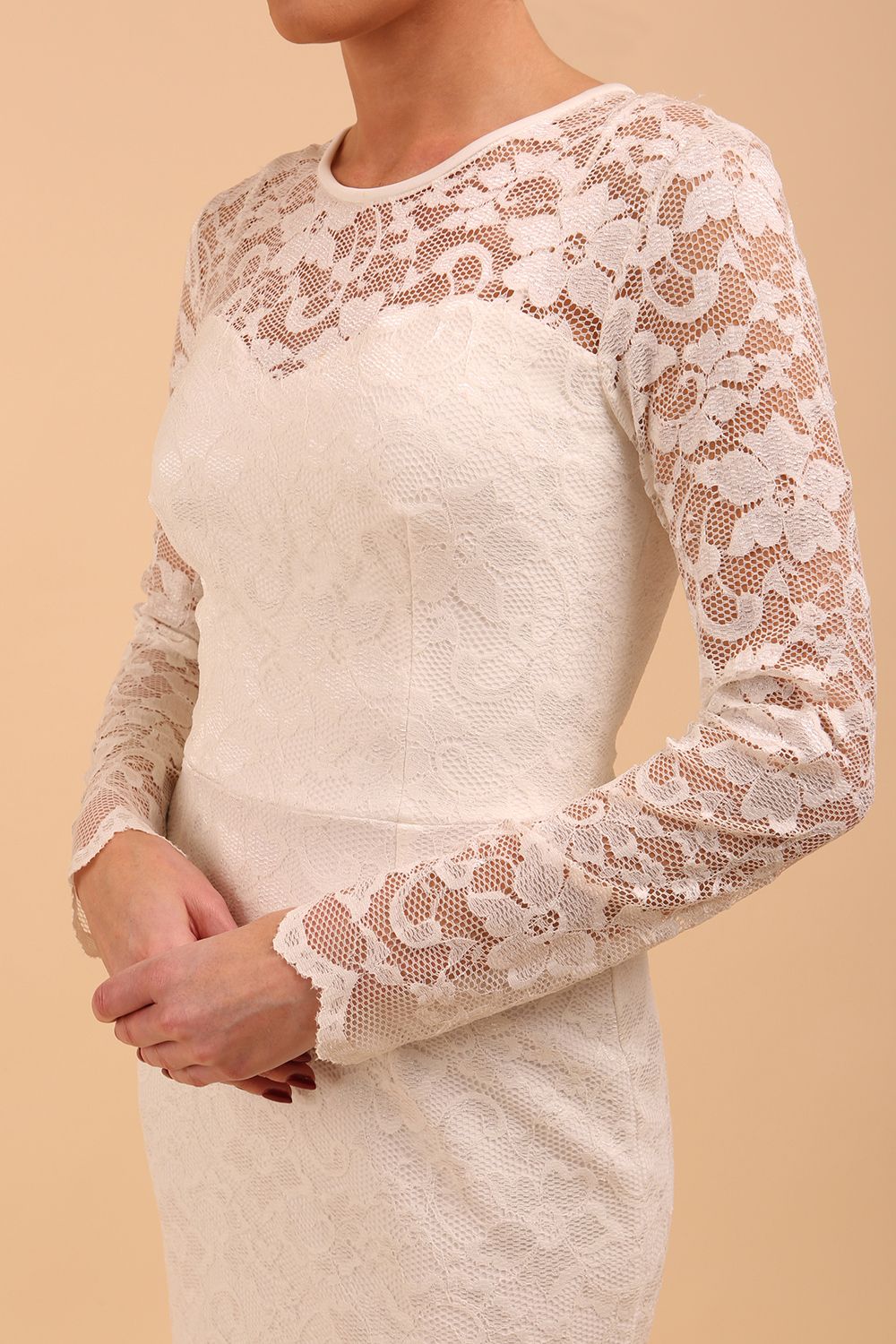 Model wearing a diva catwalk Montana Lace Dress with long lace sleeve and knee length with round lace neckline  in Ivory Cream colour front side