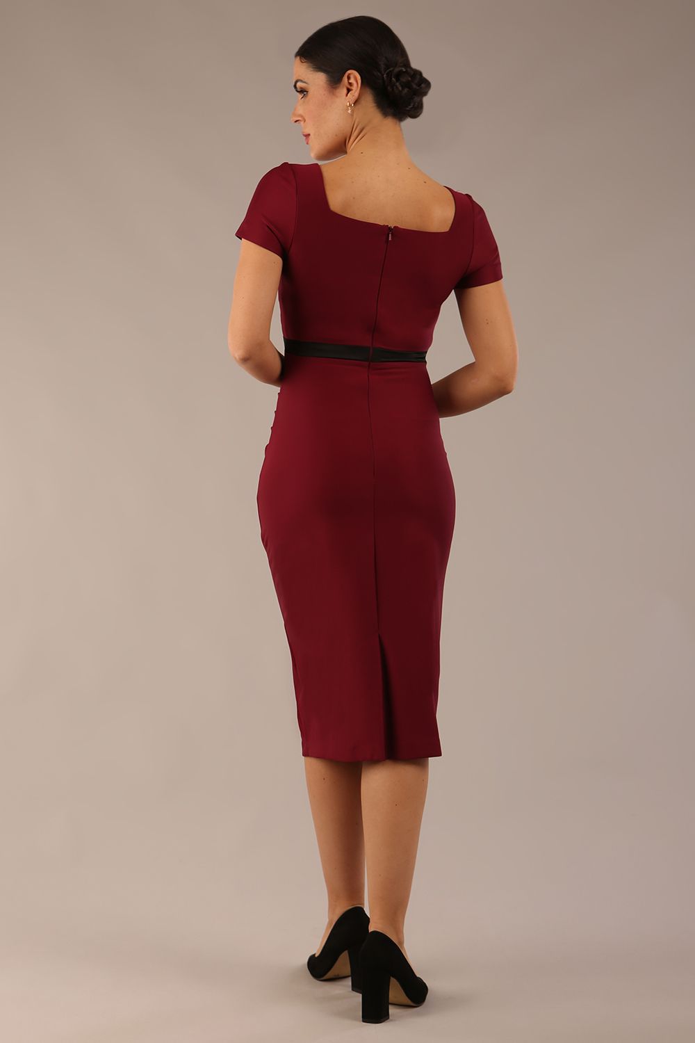model is wearing a diva catwalk dress in burgundy with black satin detail contrast on the neckline and waistband short sleeves and pleating details with knee length back