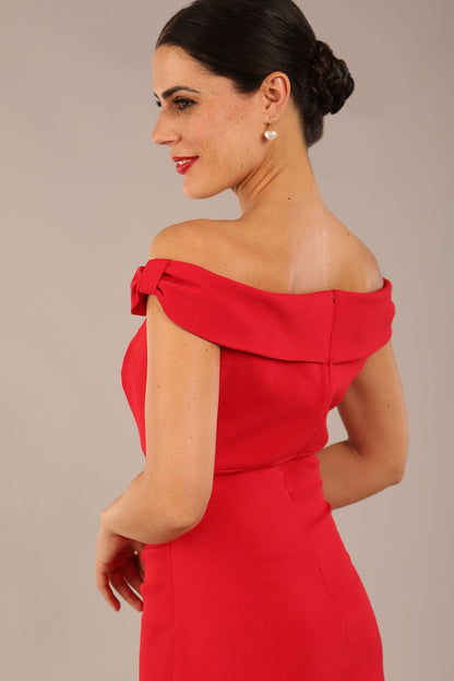brunette model wearing a diva catwalk cloud pencil fitted flattering dress off shoulder sleeveless with detail with pleating around the front in scarlet red front close up