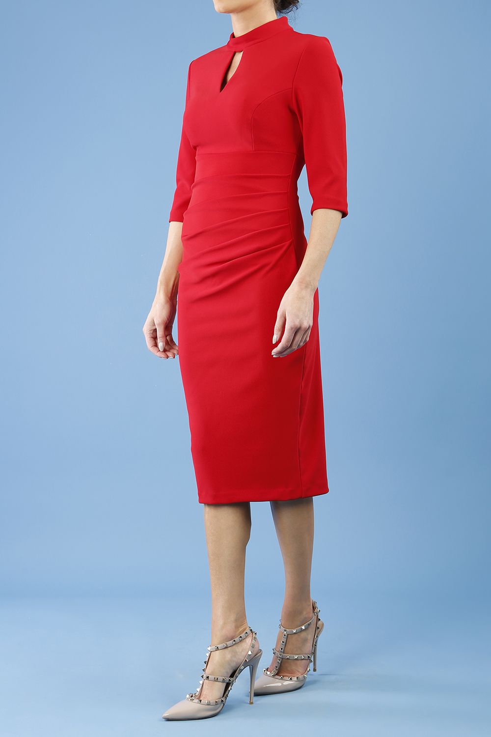 model is wearing diva catwalk pinhoe pencil dress with sleeved and high neckline with a keyhole detail in the middle and pleating across the tummy area in true red front
