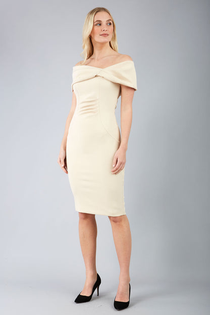 blonde model is wearing diva catwalk mariposa pencil dress with Detailed Bardot neckline with fold-over detail and pleated at waist area in beige front