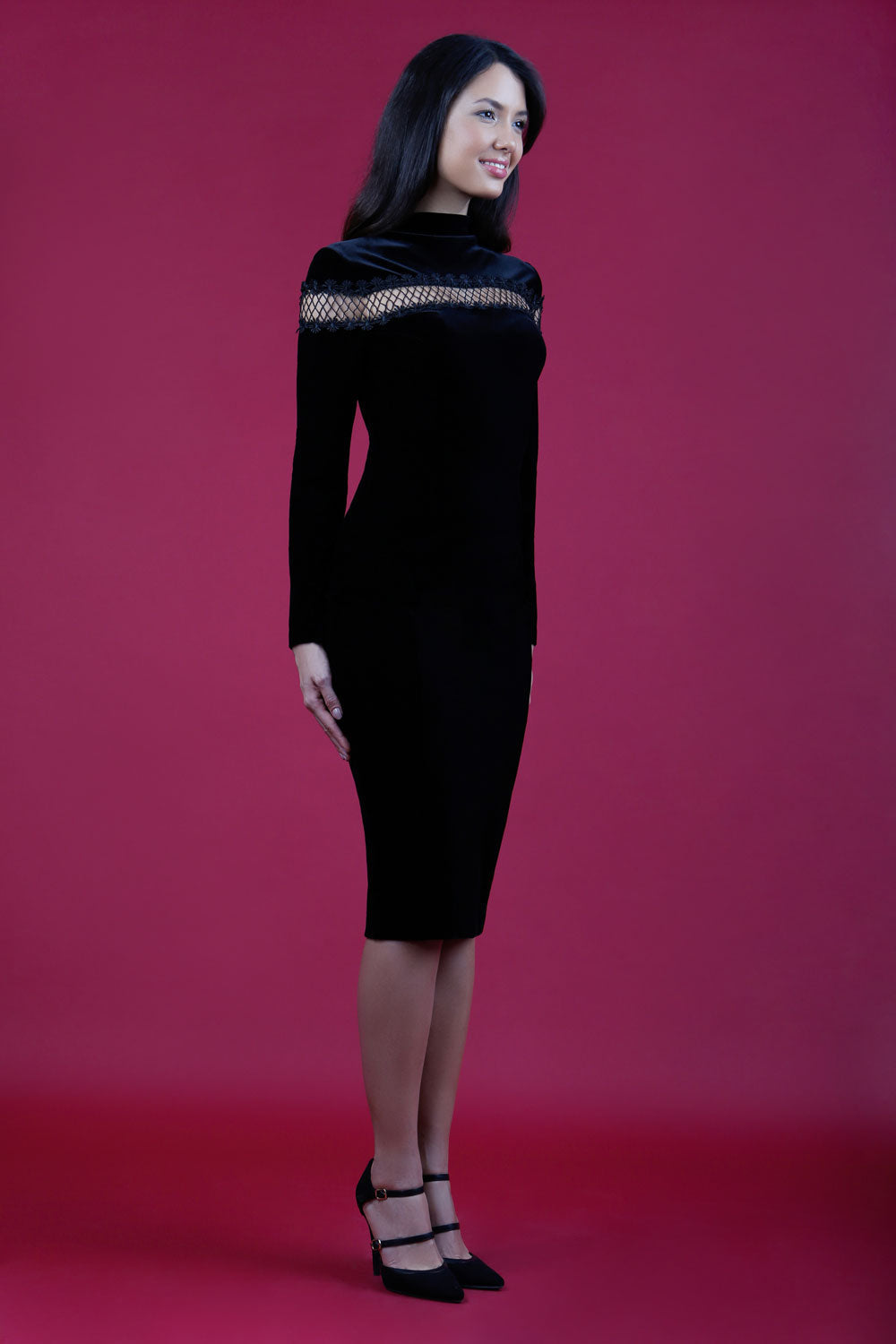 blonde model wearing diva catwalk black pencil dress called trocadero pencil midaxi style with funnel neckline and lace detail and long sleeves front