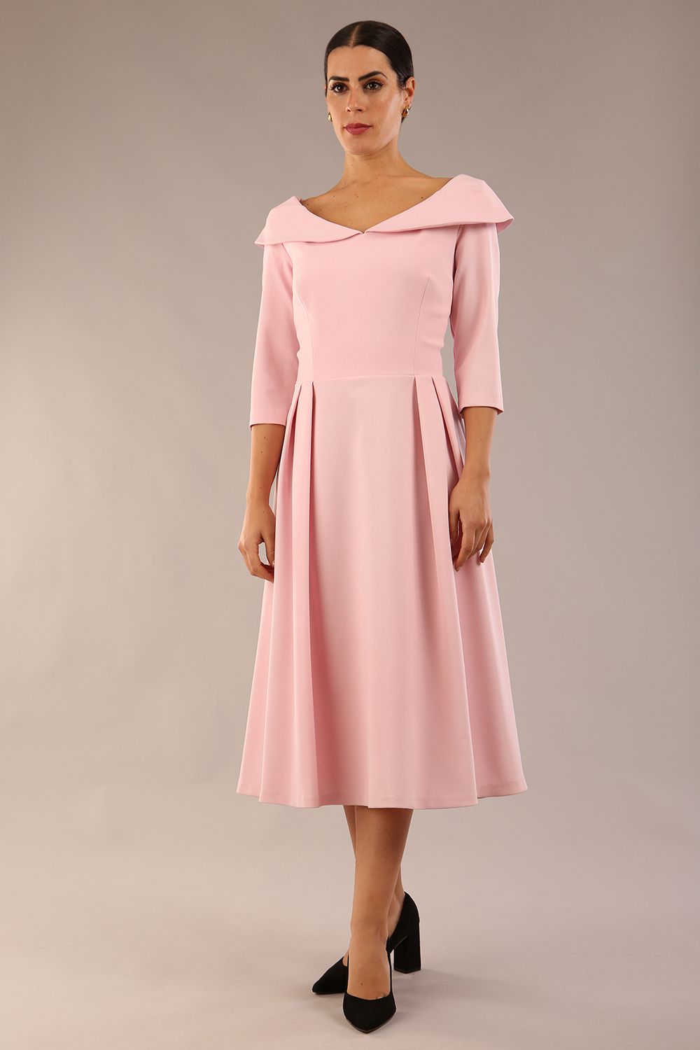Model wearing Diva Catwalk Chesterton Sleeved dress with oversized collar detail and a-line swing pleated skirt in colour crystal Pink