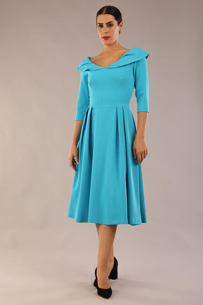 Model wearing Diva Catwalk Chesterton Sleeved dress with oversized collar detail and a-line swing pleated skirt in colour azure blue front side