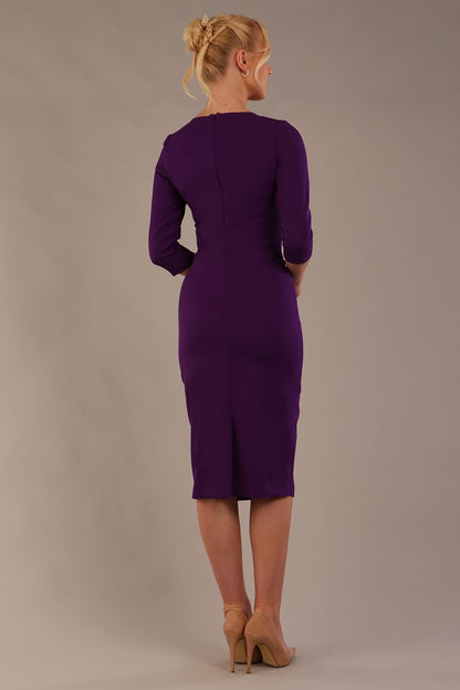 model is wearing the Diva Catwalk Ubrique pencil dress with Long sleeves and keyhole detail in Deep Purple fabric colour (Deep Purple)
