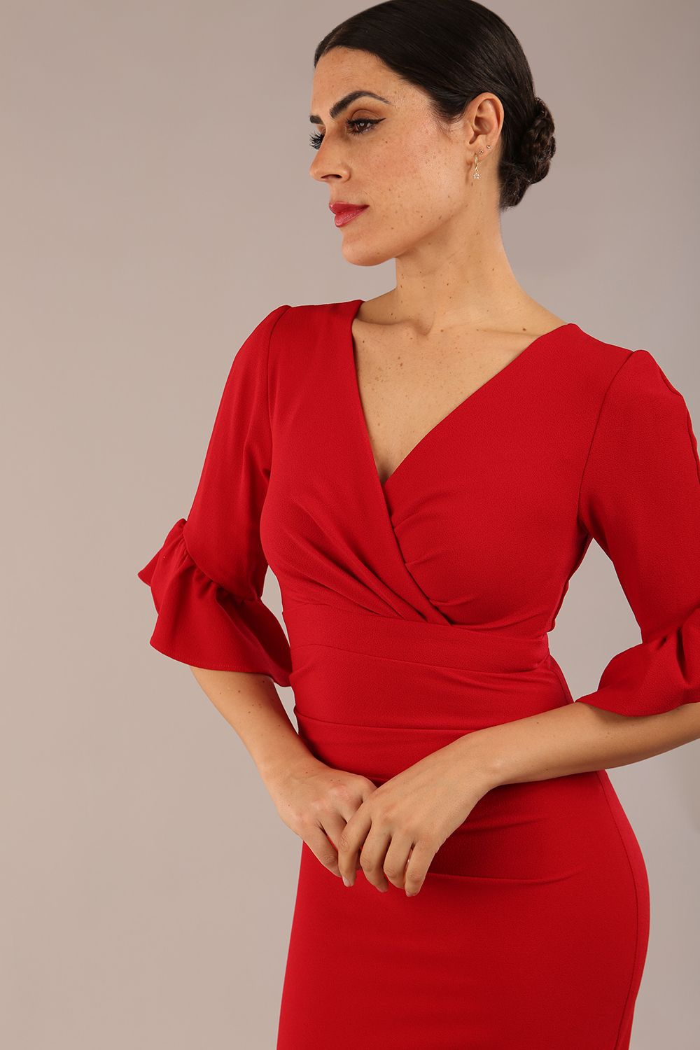 brunette model is wearing diva catwalk hollie pencil dress with frilled flute sleeve and low v-neck cut in scarlet red front close up