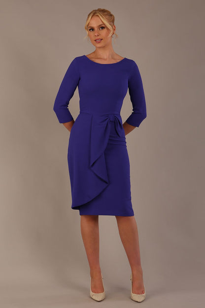 model is wearing diva catwalk jacky dress with rounded neckline 3/4 sleeve and bow detail on the waist in spectrum indigo front view