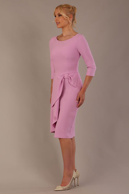 model is wearing diva catwalk jacky dress with rounded neckline 3/4 sleeve and bow detail on the waist in dawn pink front view